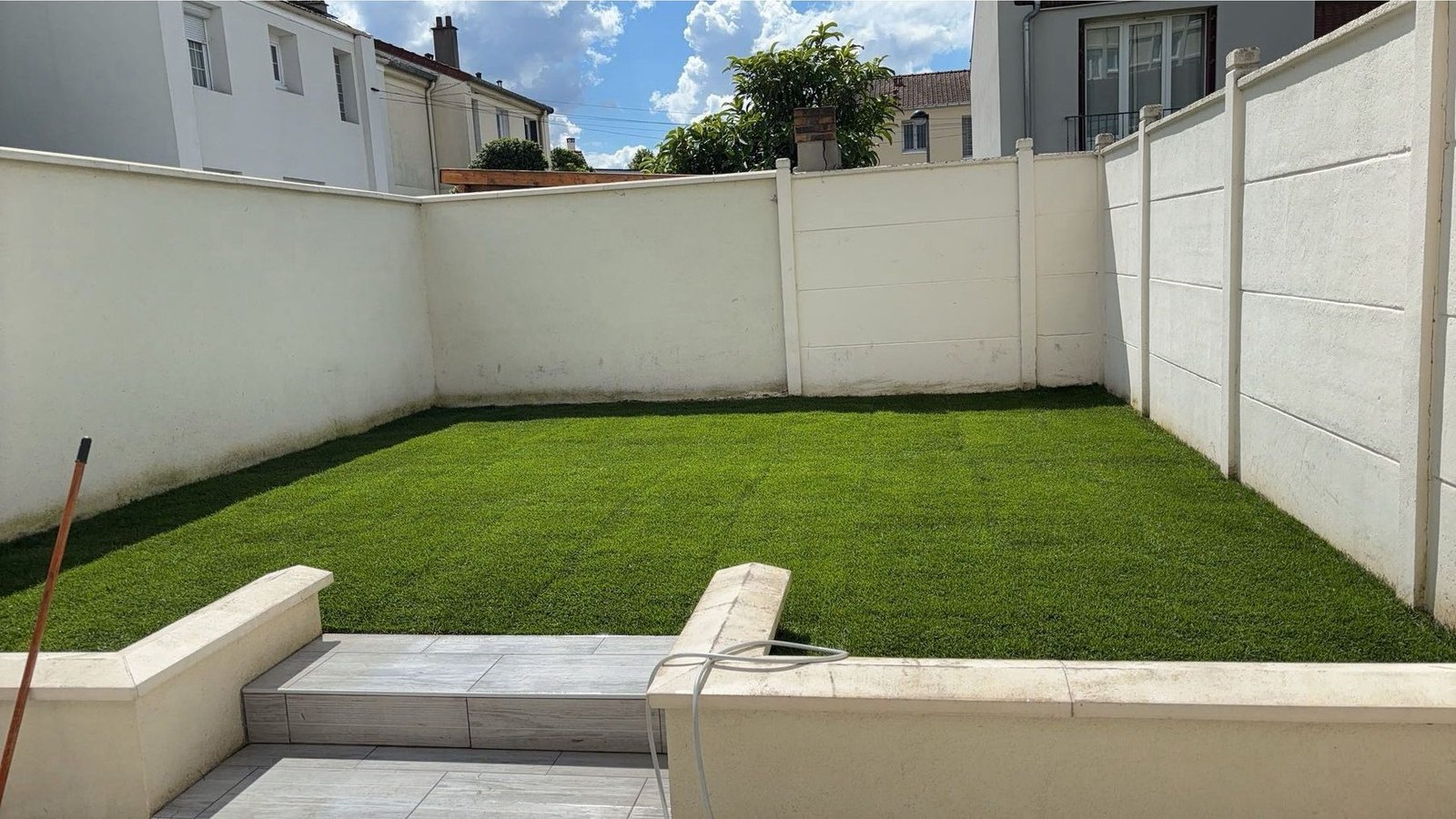 Gazon synthétique posé dans un jardin clos
